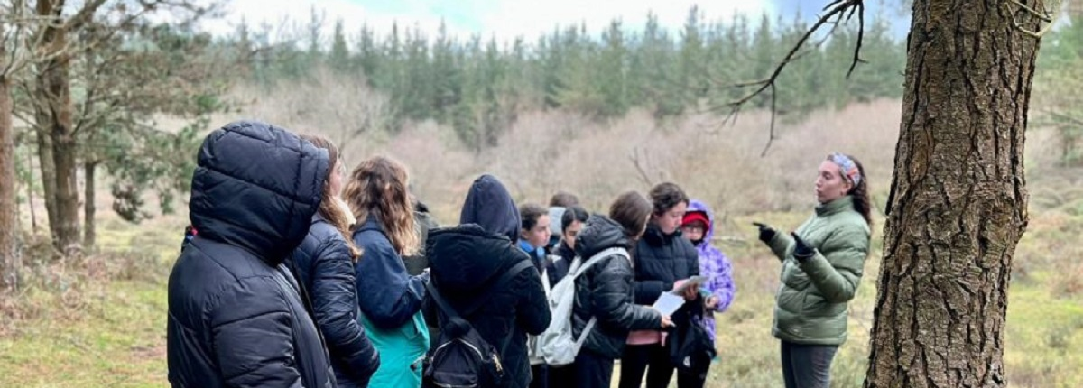 grupo de jóvenes con monitora en el bosque